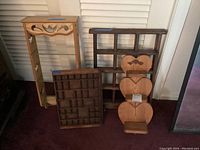 Four wooden shelving units of various sizes including one with glass shelves and a decorative carved shelf.