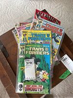 Front view of the comics collection showing multiple Marvel Transformers comic books stacked with protective bags and boards.