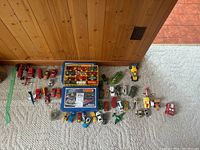 Overview of lot on carpet: two blue Matchbox mallette cases with rows of vehicles in trays and numerous loose vehicles arranged around.