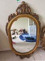 Full front view of the gilt frame mirror showing ornate carved wooden frame and clear reflective surface.