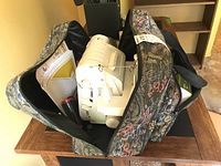 Serger and accessories inside tapestry bag, view from above