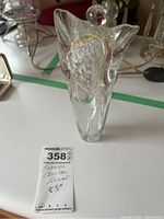 Front view of the signed clear crystal figurine showing the rounded top and textured internal details with gold highlights.