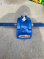 Blue Ab Slide device with foam handles resting on concrete floor.