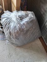 Photo showing bean bag chair cover and a clear plastic bag containing filling material.