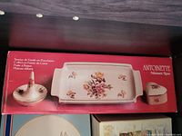 Photo of boxed porcelain Antoinette Meissen Rose set with vanity tray, ring holder, and soap dish featuring floral designs.