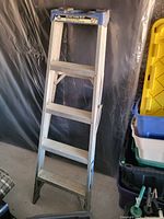 Photo of a four-step aluminum ladder showing its overall condition and structure.