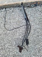 Three black flexible LED string lights attached to a single solar panel with a stake base for garden or outdoor use.