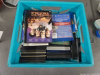 Top-down view of blue crate filled with assorted DVDs and Blu-rays, including visible titles like 'The Apartment' and others.