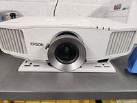 Front view of Epson projector showing lens assembly, ventilation grilles and Epson logo