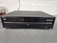 Front view of the Kenwood DP-R4450 multiple compact disc player powered on, showing the digital display and front controls.