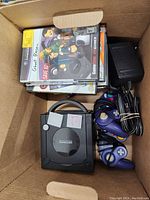 Overhead view of open moving box containing console, controllers, cables, games