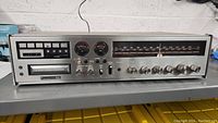 Front view showing the entire stereo receiver including 8 track tape player, VU meters, control knobs, and AM/FM radio dial.