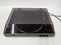 Front view of Sony PS-LX300USB turntable with dust cover closed, showing the unit surface and control buttons.