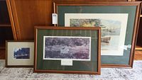 Photo showing three framed fishing scene prints arranged on floor against a wooden backdrop, highlighting frame style and matting colors.
