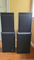 Four Bose speakers, two Model 31 and two Model 201 Series III, showing front fabric-covered grilles and overall condition including paint drops.