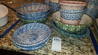 Photo showing assorted Gerald Henn pottery bowls on countertop, various sizes and colors including blue, green, and reddish speckled finish.