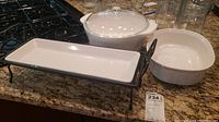 CorningWare casserole dishes, one with lid, and Pampered Chef raised serving tray on granite countertop