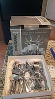 Box showing Farberware Pro 21-piece deluxe stainless steel fondue set with colorful fondue forks and stainless utensils in a box.