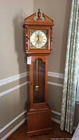 Full view of the tall wooden grandmother clock showing entire height and form.