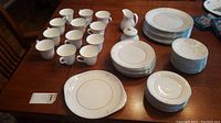 Overview of the Royal Doulton china set including cups, creamer, sugar bowl, and stacked plates in multiple sizes.