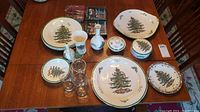 Full set displayed on table showing plates, vases, glasses, and covered dishes with Christmas Tree design