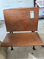 Front view of the wooden desk backrest and seat showing wood grain and scratches