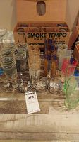 Full set of Libbey Smoke Tempo Caddy glassware showing multiple patterned glasses in original box