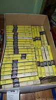 Box filled with over 30 vintage Nancy Drew books with yellow spines, showing many volumes in a collectible set.