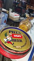 Stack of metal beer trays with Piel’s Light Beer tray on top
