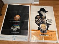 Both movie posters laid on the floor, showing overall condition, visible crease folds and general wear.