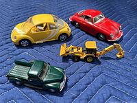 Photo of yellow Volkswagen Beetle, red Porsche 356B, yellow John Deere backhoe loader, and dark green Chevrolet pickup truck models