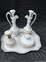 Full view of the 5 piece white ceramic vanity set on scalloped gold-trimmed tray