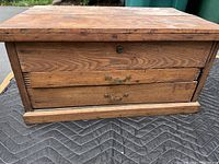 Front view of vintage oak machinist tool box cabinet showing two drawers with brass handles and lock.