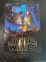 Front view of the Star Wars 1977 poster with artwork showing characters and Star Wars logo.