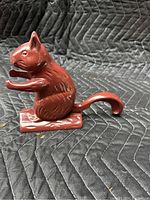 Side profile showing the detailed red enamel finish and the squirrel's shape, tail, and base.