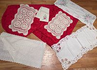 Full set of 6 vintage linens arranged showing red oval tablecloth, 2 tatted scarves, embroidered runner and small cloths