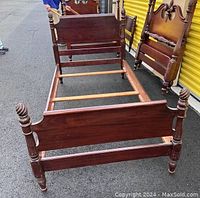 Full view of assembled vintage mahogany twin 4-poster bed frame showing headboard, footboard, wooden side rails, and support slats.