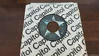 45 RPM vinyl record of Ringo Starr's "Photograph" in a Capitol Records paper sleeve with visible Capital branding and star label.