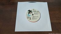 Top-down view of the front label of one Tone Loc Funky Cold Medina 45rpm record in a white paper sleeve showing colorful palm tree label design.
