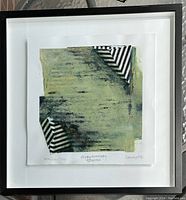 Framed abstract watercolour artwork showing mainly green brushstrokes and two black and white striped corner elements, presented under glass with white mat.