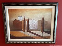 Framed modern art landscape painting showing stylized buildings and three tall trees casting shadows, with a muted color palette and good condition.