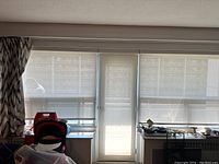 Three textured roller blinds installed on windows and door: two wide blinds on windows and one narrow on door, all light-filtering beige fabric.
