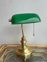 Front view of lamp showing green glass shade and brass base