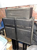 Photo showing two Bose 301 speakers on stands with a Yamaha center speaker on top, all covered in dust.