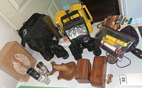 Photo showing overall camping gear lot including binoculars, flashlights, wooden boxes, shot glasses, cork block, compass, carrying bag, and small accessory items.