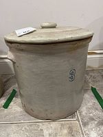 Front view of the stoneware crock with matching lid, stamped number 3.