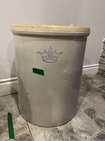 Front view of beige/cream stoneware crock with blue crown logo and number 10, showing size approx 19.5 inches.