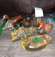 Photo showing all eight duck figurines including two yellow clear resin ducks at front and six wood ducks behind.