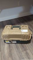 Closed beige Plano tackle box showing top handle and two cup holders on lid.
