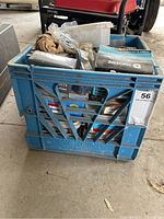 Milk crate filled with various boxes of nails and screws, showing assortment and condition